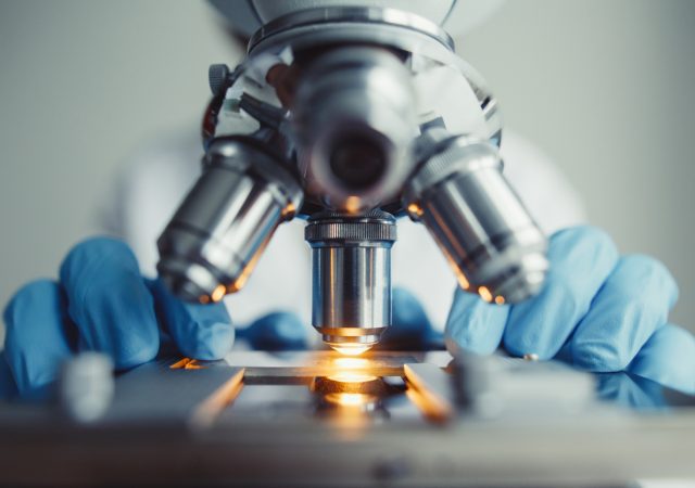Close up of examining of test sample under the microscope