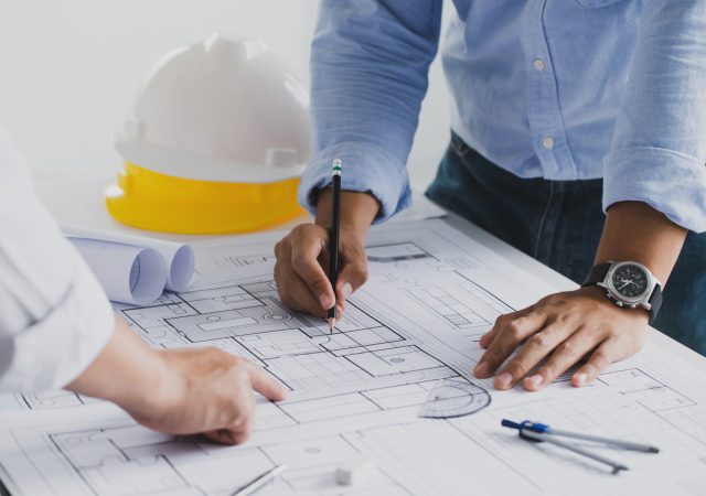 engineer meeting for an architectural project. working with partner and engineering tools working on blueprint architectural project at the construction site at desk in the office.